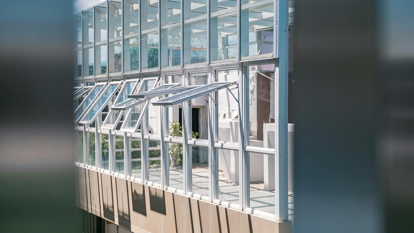 Modern building facade with glass panels and white metal frames.