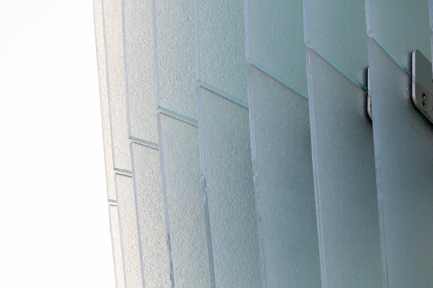 Textured glass panels connected by metal fasteners.